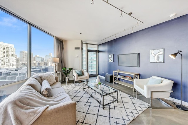 living room with expansive windows, rail lighting, and a healthy amount of sunlight