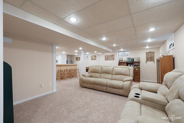 carpeted living room with a paneled ceiling and indoor bar