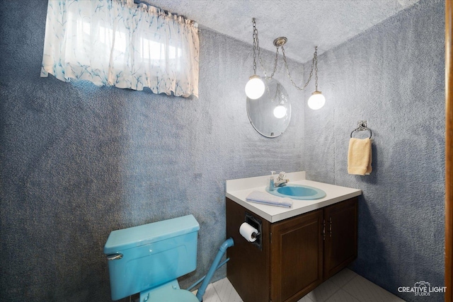 bathroom with toilet, vanity, and tile patterned floors