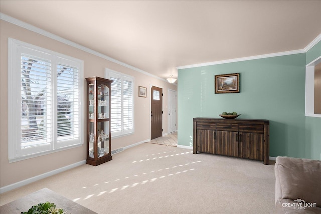 carpeted foyer with crown molding