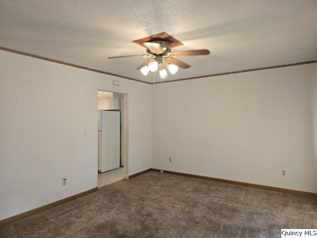 empty room with crown molding, ceiling fan, dark carpet, and a textured ceiling