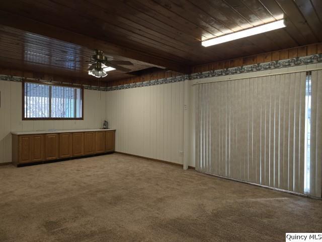 carpeted empty room featuring wooden ceiling and ceiling fan