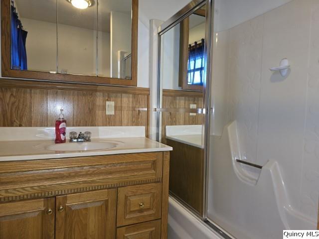 bathroom with bath / shower combo with glass door and vanity