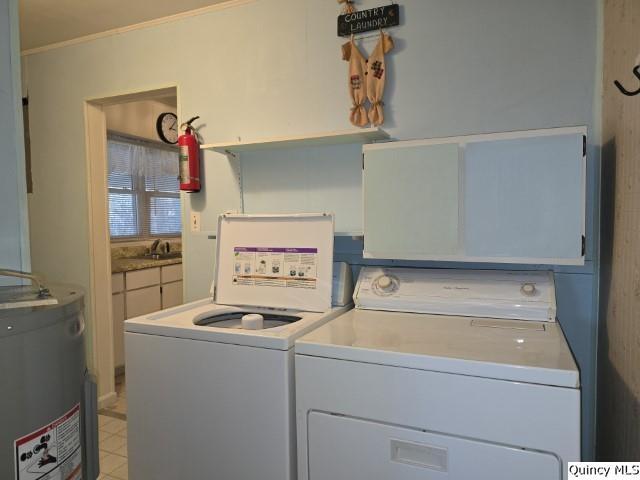 washroom featuring cabinets, gas water heater, sink, and washer and clothes dryer