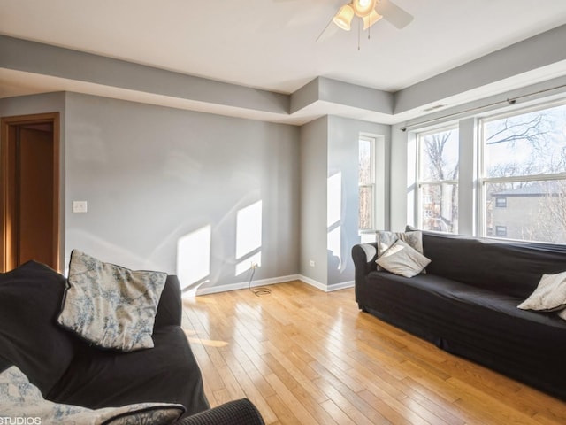 living room with light hardwood / wood-style floors and ceiling fan