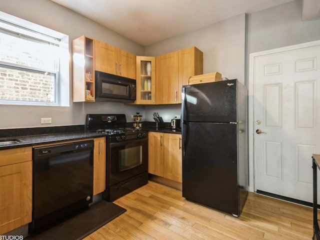 kitchen featuring sink, black appliances, and light hardwood / wood-style floors