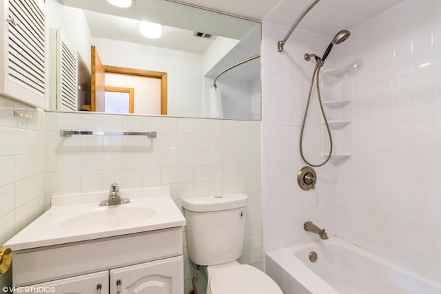 full bathroom with tile walls, vanity, tasteful backsplash, toilet, and tiled shower / bath