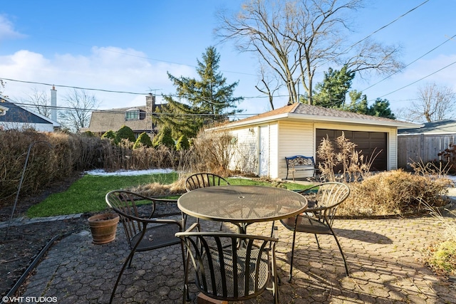 view of patio with an outbuilding and a garage