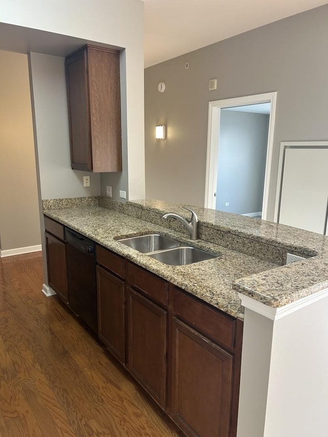 kitchen with sink, dishwasher, light stone counters, and kitchen peninsula