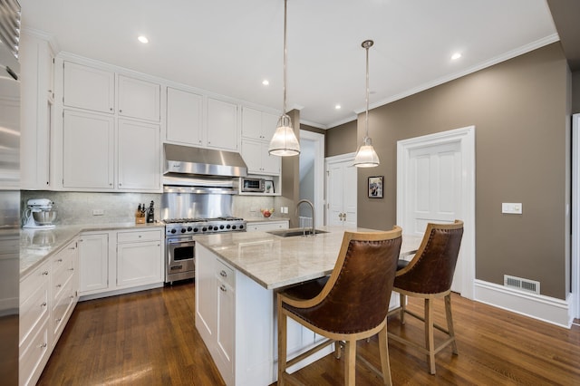 kitchen featuring decorative backsplash, sink, appliances with stainless steel finishes, an island with sink, and white cabinets