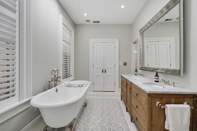 bathroom featuring vanity, tile patterned flooring, and a tub