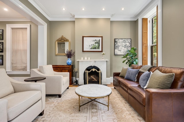 living room featuring light wood-type flooring, a high end fireplace, and crown molding