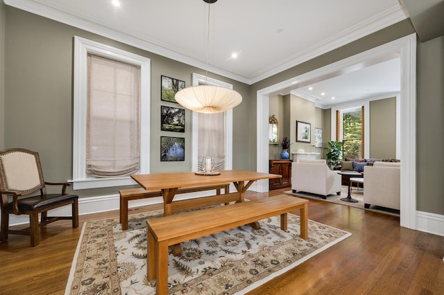 dining area with dark wood-type flooring and ornamental molding