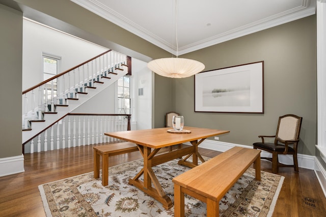 dining area with dark hardwood / wood-style flooring and crown molding