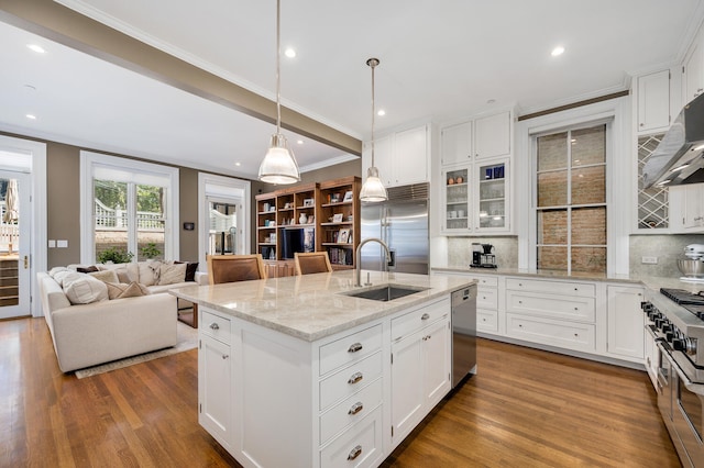 kitchen featuring white cabinetry, decorative backsplash, high quality appliances, and a kitchen island with sink