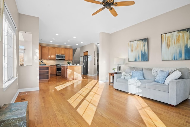 living room with ceiling fan and light wood-type flooring