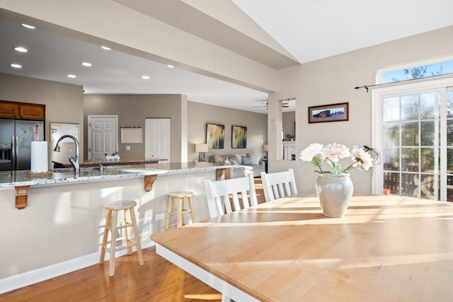 dining room featuring vaulted ceiling, ceiling fan, sink, and light hardwood / wood-style floors