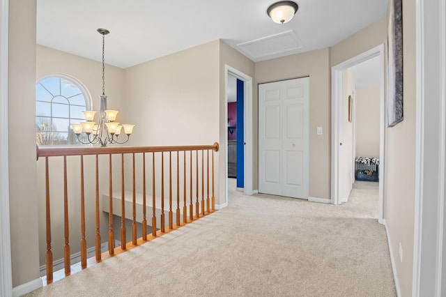 hallway with light colored carpet and a chandelier