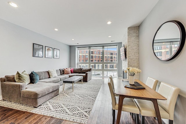 living room featuring a wall of windows and wood-type flooring