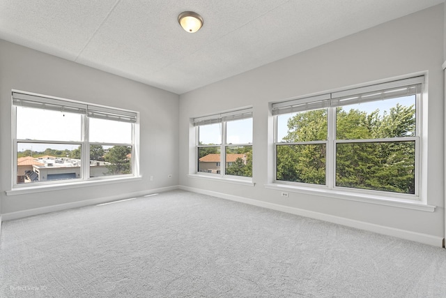 carpeted empty room featuring lofted ceiling and a textured ceiling