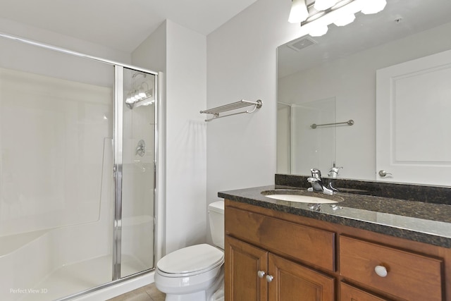 bathroom with vanity, toilet, tile patterned floors, and a shower with door