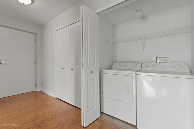 laundry area featuring light hardwood / wood-style floors and washing machine and clothes dryer