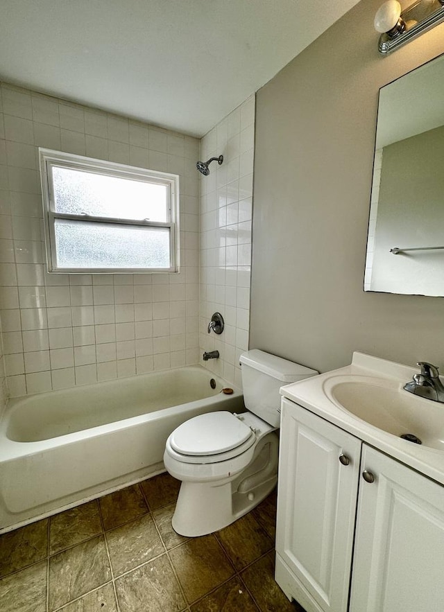 full bathroom featuring toilet, vanity, and tiled shower / bath