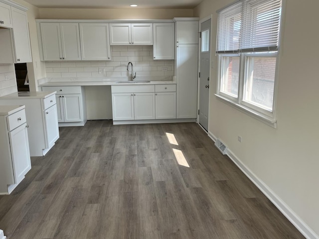 kitchen with white cabinets, backsplash, dark hardwood / wood-style flooring, and sink