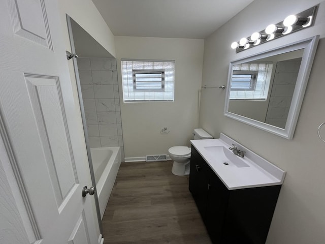 full bathroom featuring toilet, hardwood / wood-style flooring, vanity, and bathtub / shower combination