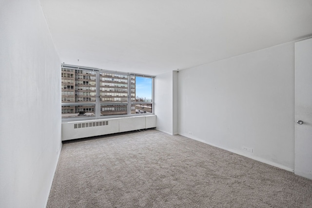 unfurnished living room featuring carpet flooring and radiator