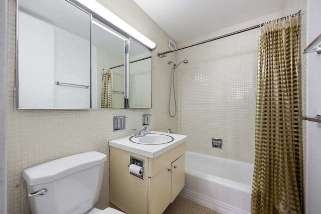 full bathroom featuring vanity, tile walls, shower / bath combo with shower curtain, and toilet