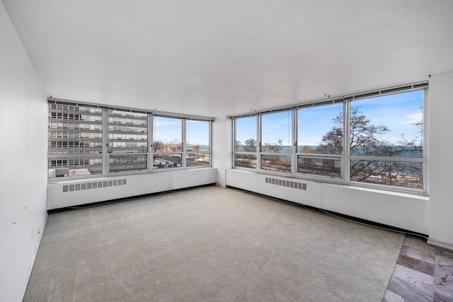 unfurnished sunroom featuring radiator heating unit