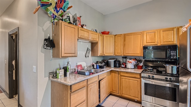 kitchen with light tile patterned flooring, appliances with stainless steel finishes, and sink