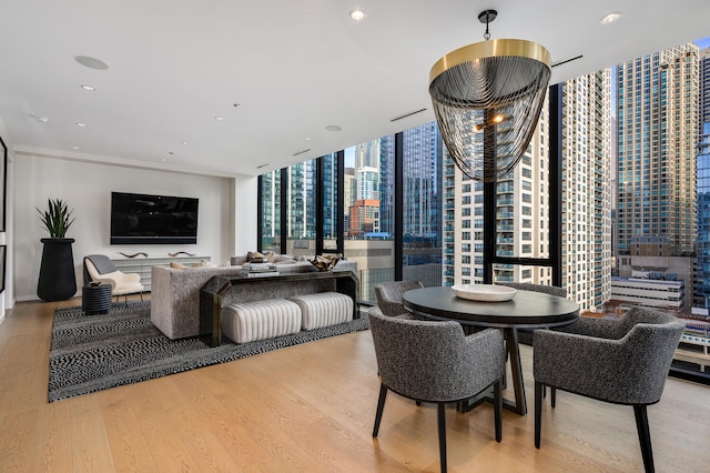 dining room with an inviting chandelier, light hardwood / wood-style floors, and floor to ceiling windows