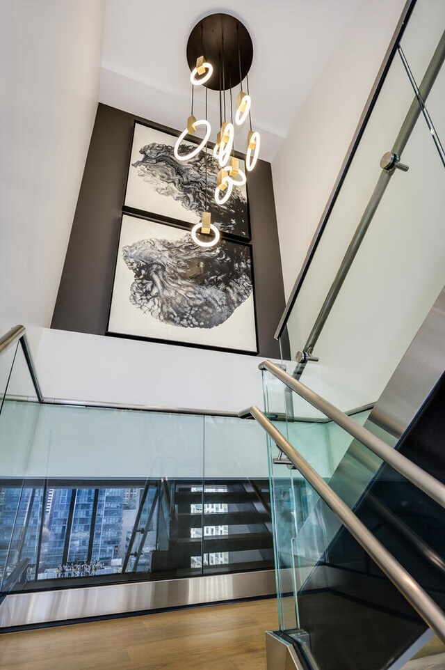 stairway featuring hardwood / wood-style floors and a chandelier