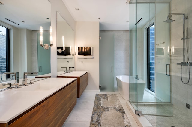 bathroom with tile patterned flooring, vanity, a wealth of natural light, and separate shower and tub