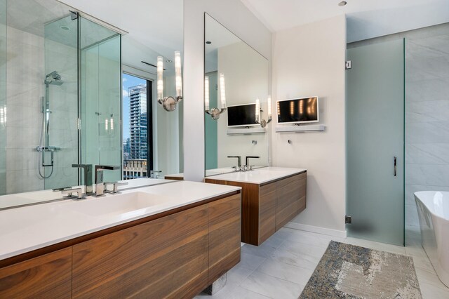 bathroom with shower with separate bathtub, vanity, and tile patterned floors