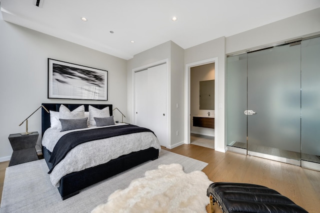 bedroom featuring hardwood / wood-style flooring and ensuite bath