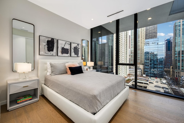 bedroom featuring hardwood / wood-style floors and a wall of windows