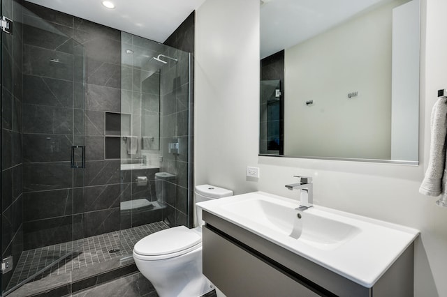 bathroom with vanity, a shower with shower door, and toilet