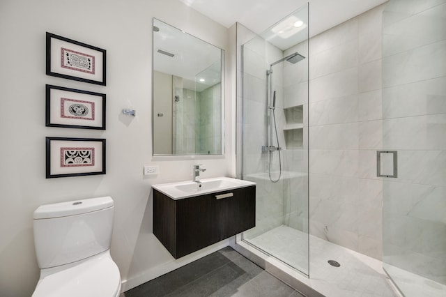 bathroom featuring vanity, toilet, and a shower with shower door