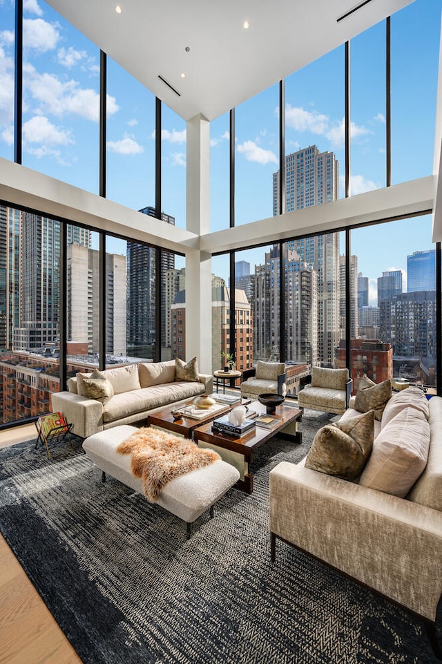 living room with plenty of natural light, expansive windows, and a high ceiling