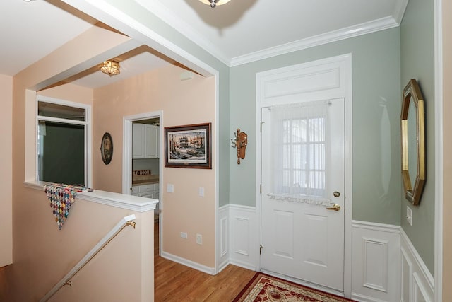 entryway with crown molding and light hardwood / wood-style flooring