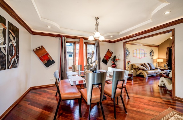 dining room featuring dark hardwood / wood-style floors, a tray ceiling, a chandelier, and crown molding