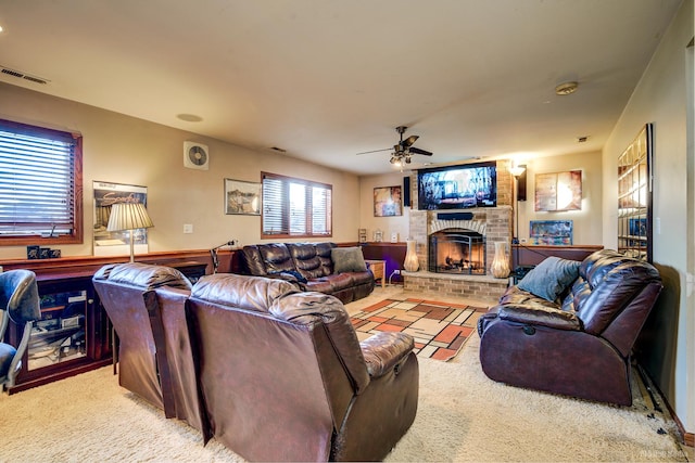 carpeted living room with a brick fireplace and ceiling fan