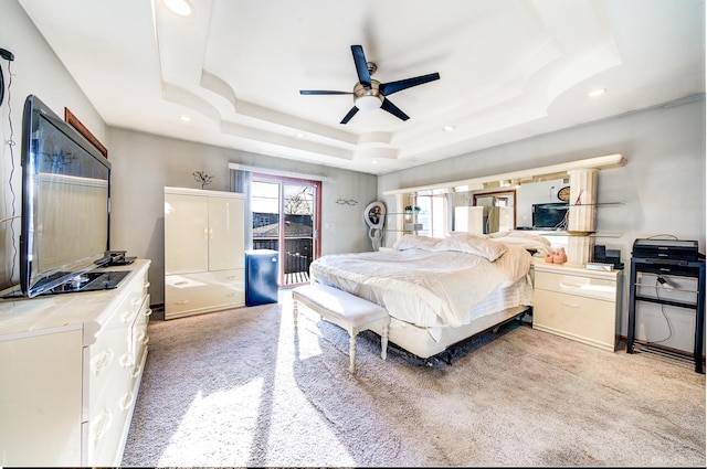 bedroom with ceiling fan, a raised ceiling, light carpet, and access to outside