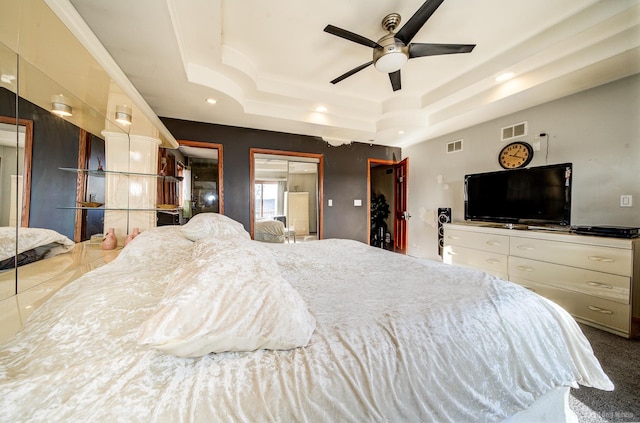 carpeted bedroom featuring a raised ceiling and ceiling fan