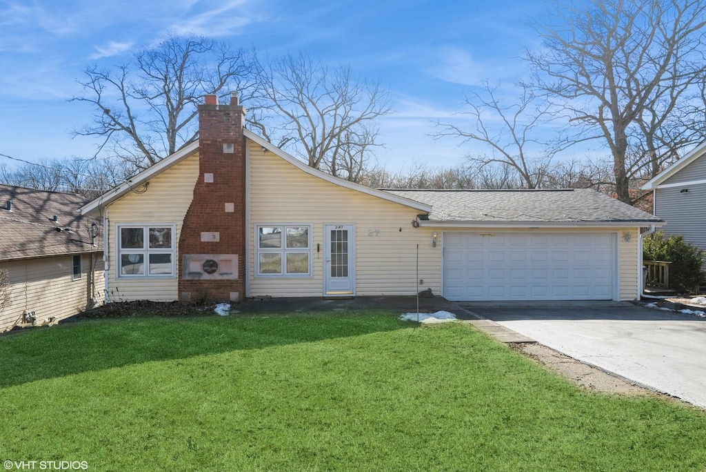 view of front of home with a garage and a front lawn