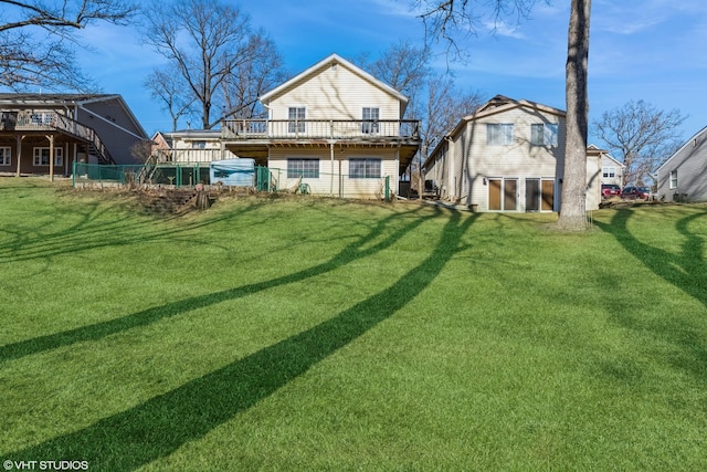 back of property featuring a deck and a lawn