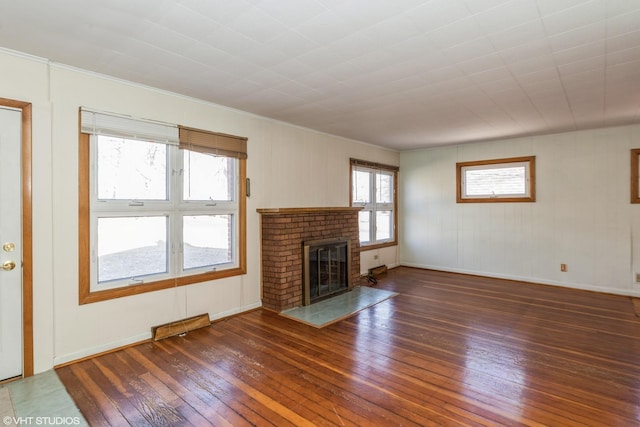 unfurnished living room with crown molding, dark hardwood / wood-style flooring, and a brick fireplace